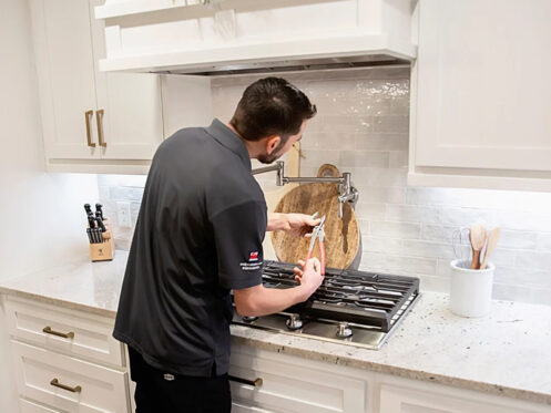 A plumber installing a pot filler.