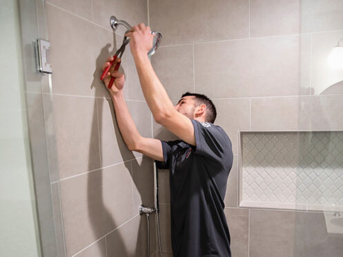 A man is installing a shower head